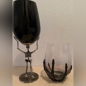 Skeleton holding a black glass and skeleton hand stemless glass. 16oz & 18oz